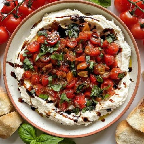 Rustic bruschetta dip with cherry tomatoes, basil, and whipped cheese, surrounded by baguette and fresh vine tomatoes
