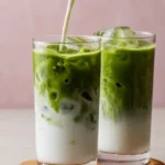 Iced matcha latte in a tall glass with ice and creamy milk