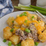 slow cooker cowboy casserole with golden tater tots and green onions served on a white plate