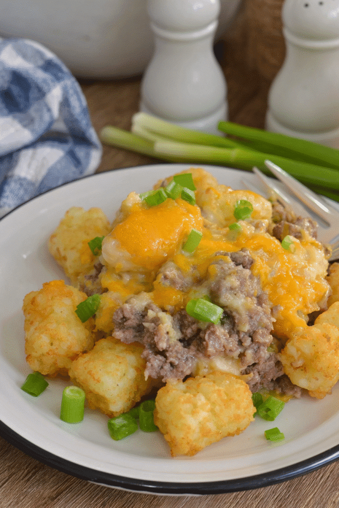 slow cooker cowboy casserole with golden tater tots and green onions served on a white plate