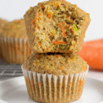 Moist zucchini carrot oatmeal muffin stacked and sliced to reveal soft, fluffy interior with colorful veggie flecks.