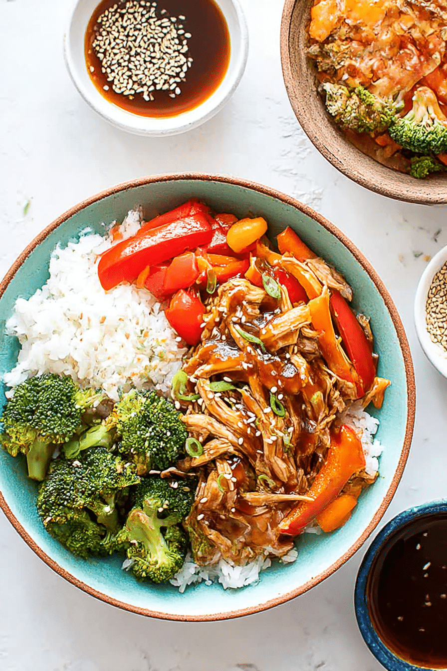 Overhead shot of easy crock pot teriyaki chicken bowl with rice, broccoli, peppers, and sauce on the side