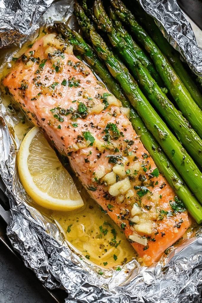 Baked salmon asparagus foil packs with garlic butter, lemon slices