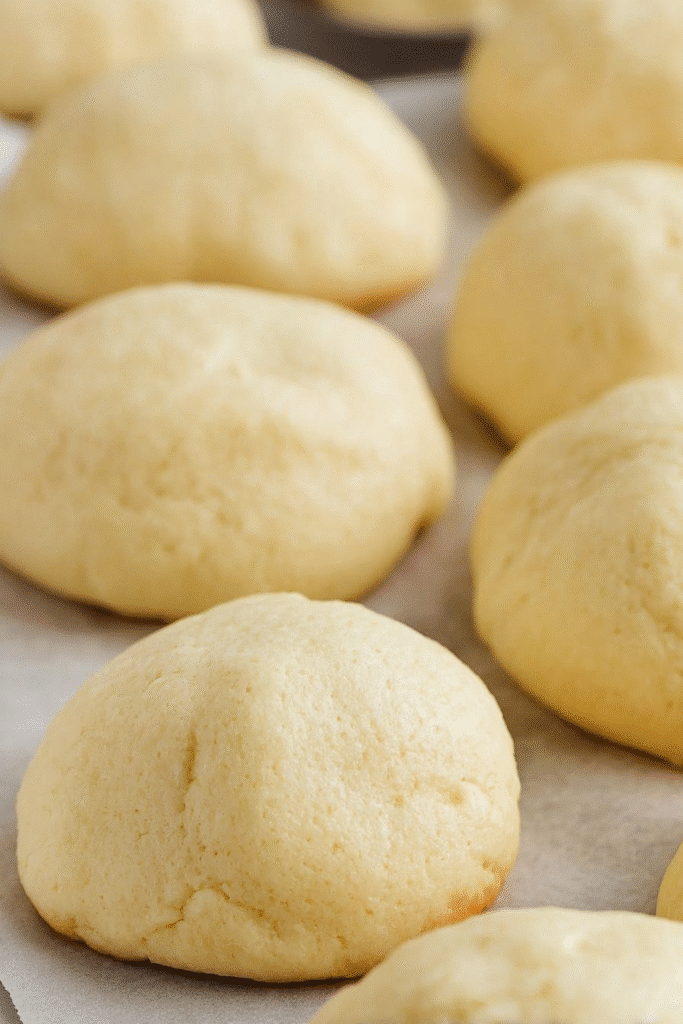 Soft and fluffy Italian ricotta cookies freshly baked on parchment paper.