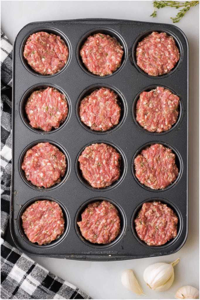 Raw meatloaf mixture in a muffin tin before baking