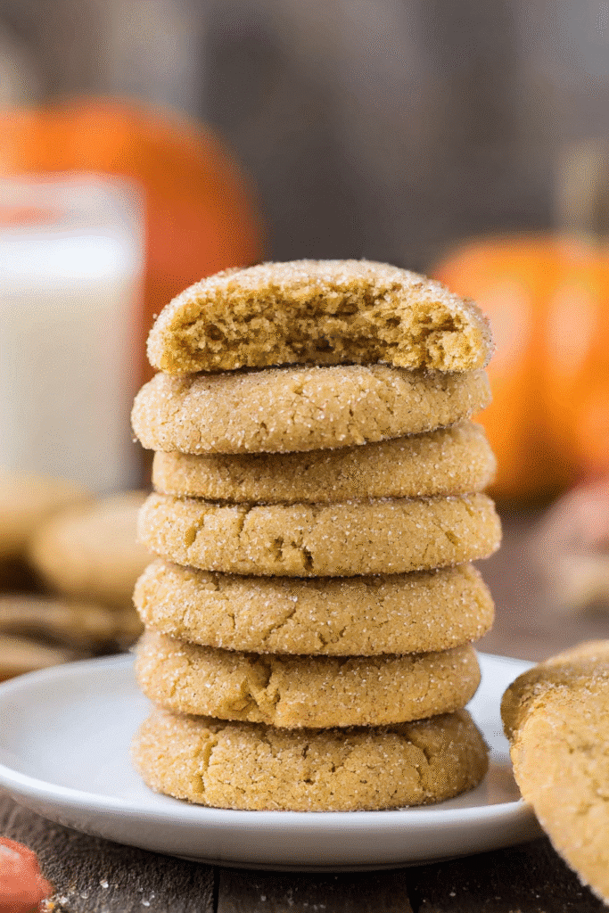 Stack of pumpkin sugar cookies with top cookie broken to reveal soft center