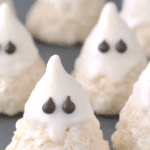 Rice Krispie Treat Ghosts shaped like teardrops with white marshmallow coating and chocolate eyes for Halloween