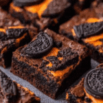 Halloween brownies with Oreo cookie pieces and orange cream filling.