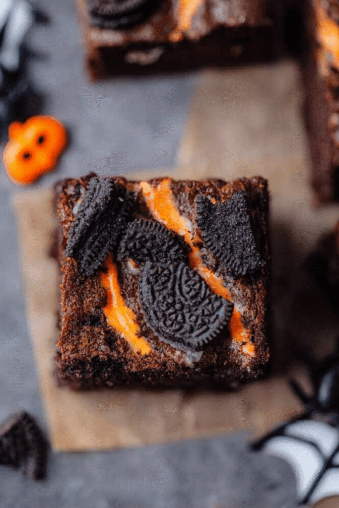 Close-up of a Halloween brownie topped with Oreo cookies and orange filling.