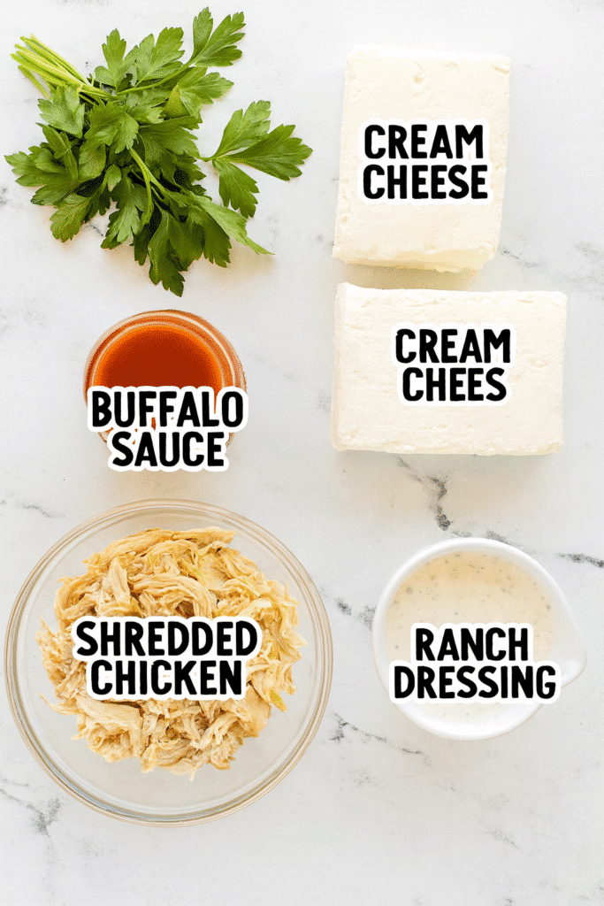 Ingredients for Halloween Buffalo Chicken Dip including shredded chicken, cheese, sauces, and a ghost-shaped cookie cutter.