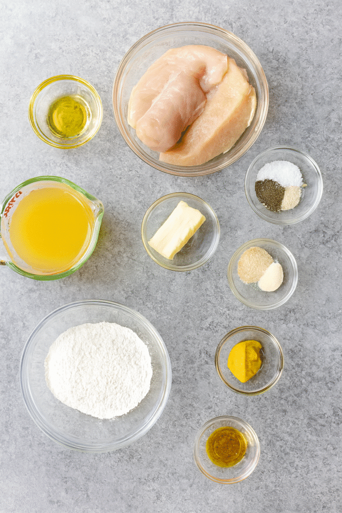 Ingredients for homestyle chicken and gravy including chicken breasts, flour, butter, broth, mustard, and spices.