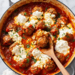 Ricotta meatballs simmered in rich tomato sauce with melted ricotta cheese and fresh parsley garnish.