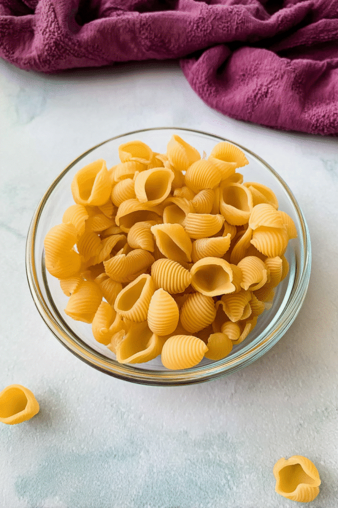 Uncooked shell pasta in a glass bowl, ready for Marry Me Chicken Soup Recipe.