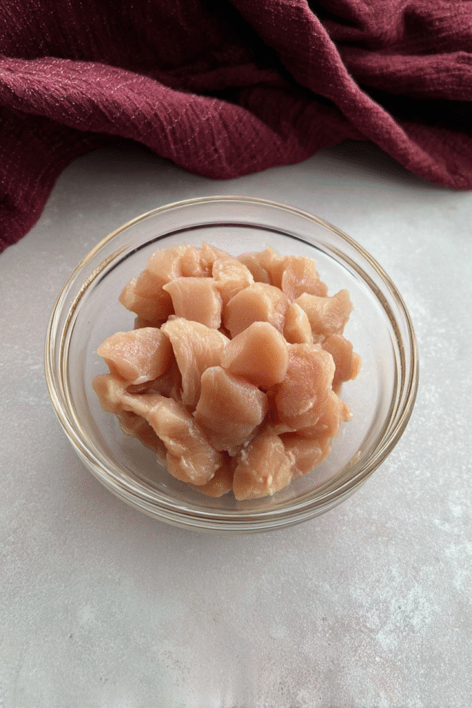 Diced raw chicken breast in a glass bowl for Marry Me Chicken Soup Recipe prep.