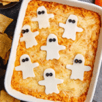 Halloween Buffalo Chicken Dip topped with ghost-shaped cheese slices and served in a white baking dish.