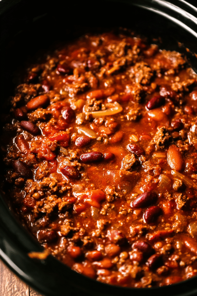 Fully cooked slow cooker chili recipe with beans, beef, tomatoes, and thick chili sauce.