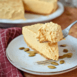 A fluffy bite of Pumpkin Fluff Pie takes center stage in this cozy close-up, showcasing its airy, whipped pumpkin filling.
