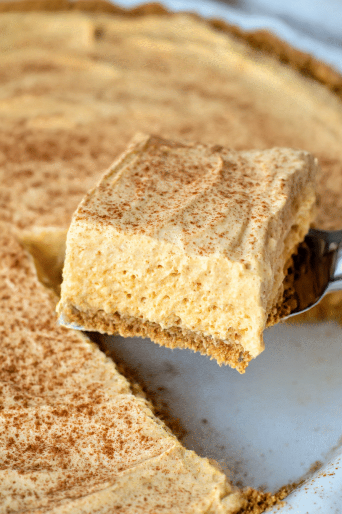 Close-up of Pumpkin Fluff Pie slice being served with fluffy texture and cinnamon topping.
