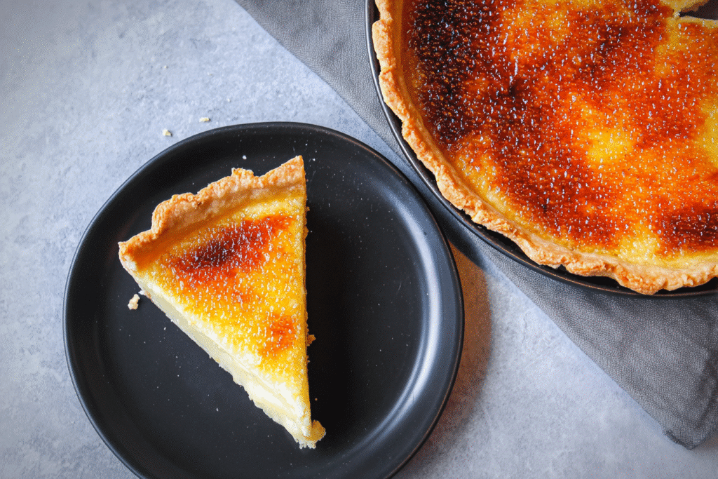 Top view of Creme Brulee Pie with a slice on a black plate