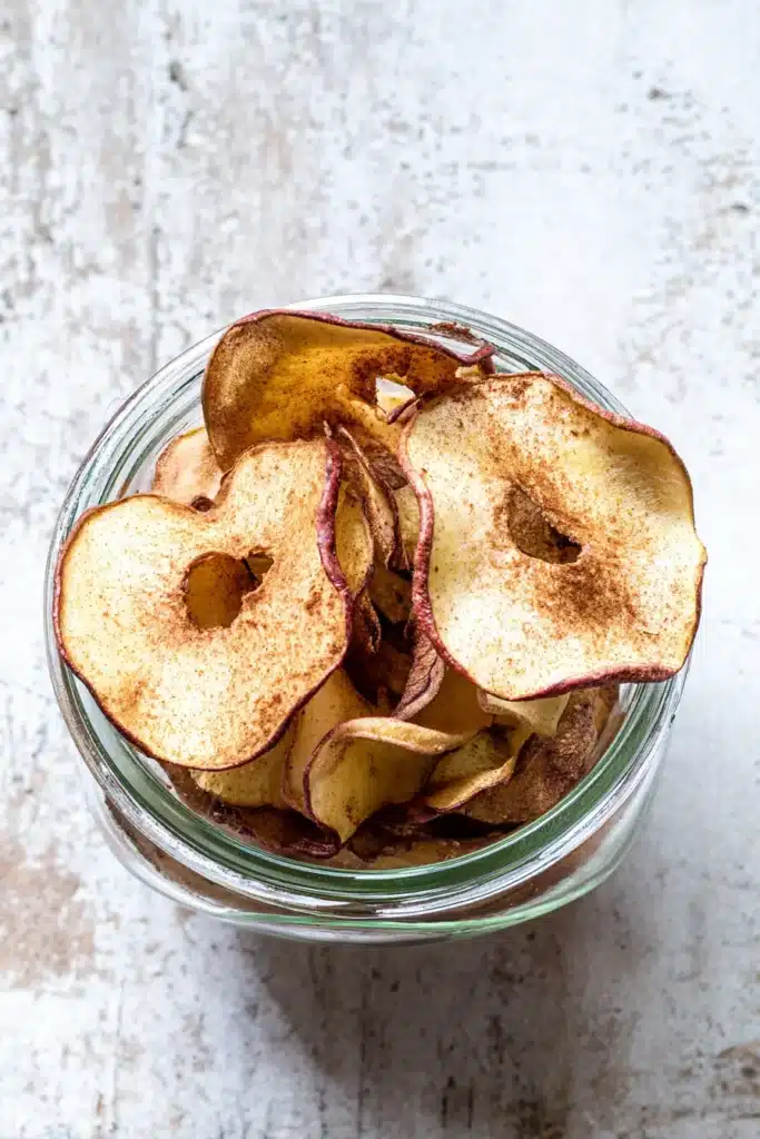 : jar of crispy air fryer apple chips on rustic background
