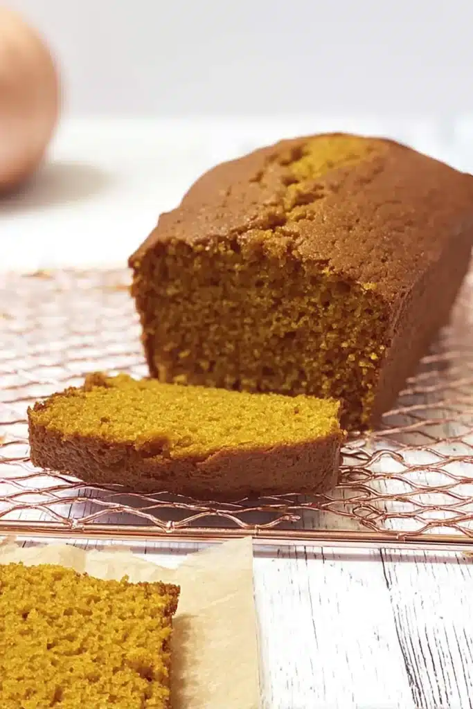 easy pumpkin bread cooling on wire rack with slice cut