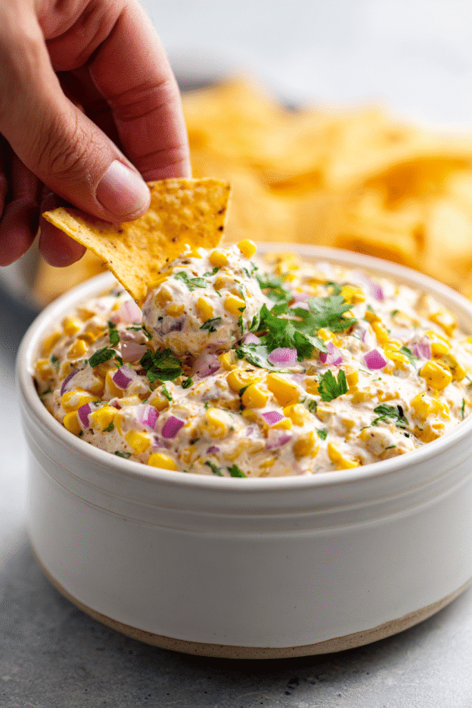 Easy traditional corn dip recipe served with tortilla chips and cilantro