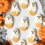 Nutter Butter Ghost Cookies decorated with white chocolate, candy eyes, and Halloween props.