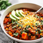 Overhead shot of Turkey Sweet Potato Chili topped with avocado, cheese, and cilantro.