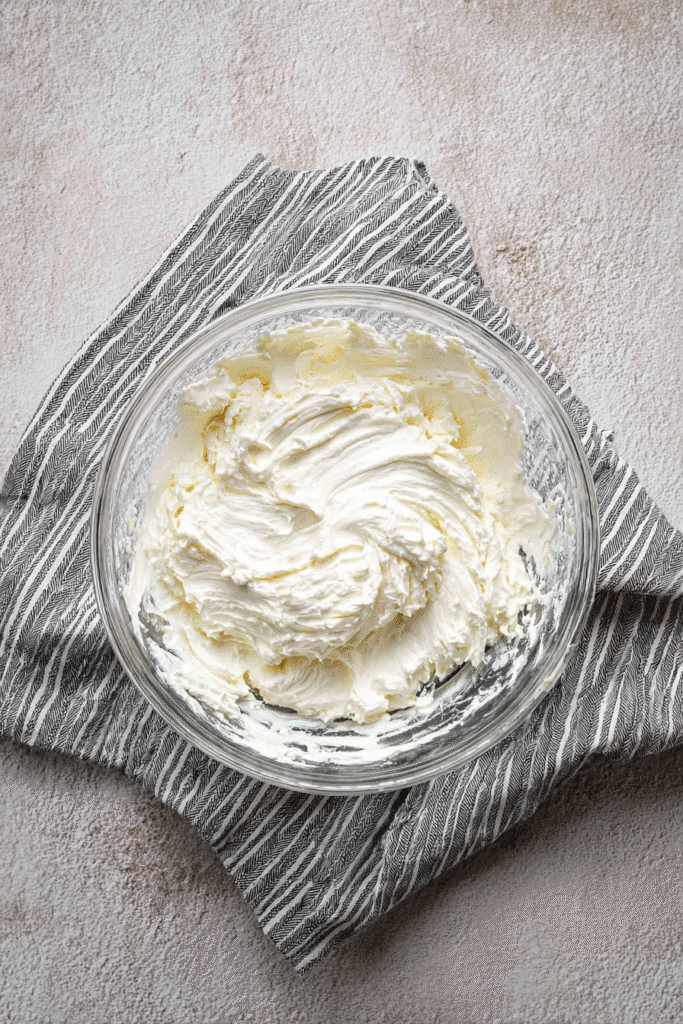 Whipped cream cheese and butter in glass mixing bowl for brownie batter dip recipe