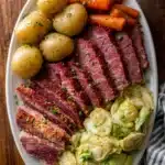 Slow Cooker Corned Beef and Cabbage Dinner. Platter of sliced corned beef, cabbage, carrots, and potatoes.