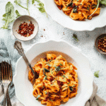 creamy sun-dried tomato pasta in skillet with spinach