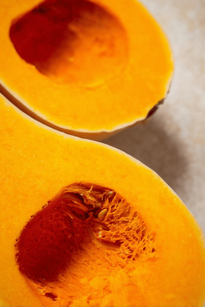 Butternut squash halves, ready for honey roasting. Close-up of the golden, cozy vegetable.