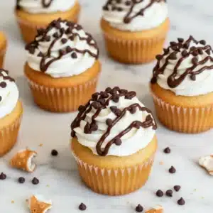 Cannoli cupcakes topped with whipped ricotta frosting and mini chocolate chips, a delightful and easy-to-make dessert.