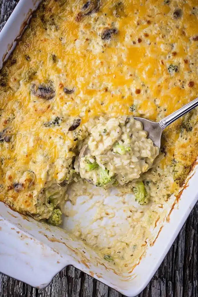 Easy broccoli rice and cheese casserole in a baking dish with a spoon. Cheesy rice casserole.