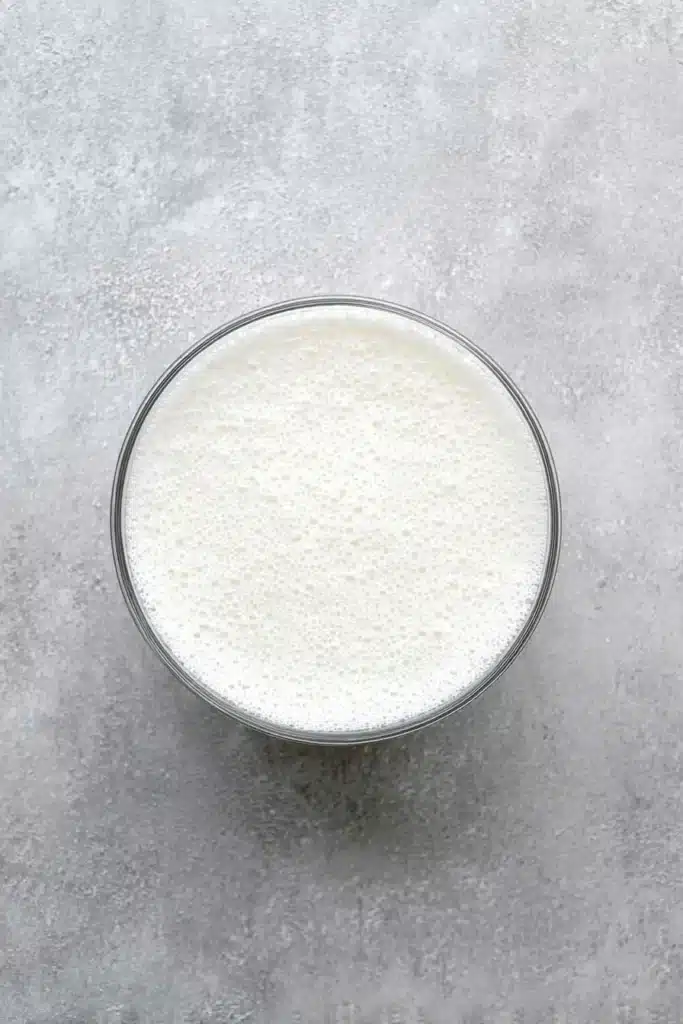 frothy white christmas punch in clear glass bowl