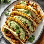 Baked Ground Turkey Tacos with Avocado Sauce drizzled with creamy sauce.