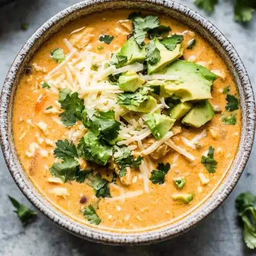 Delicious creamy white chicken chili with toppings ready to enjoy