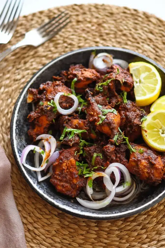 chicken chukka with onion rings and lemon on a plate
