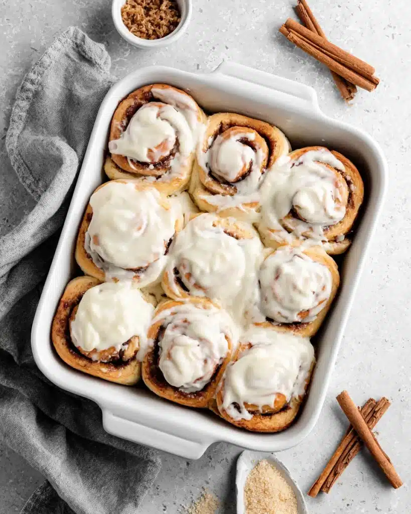 soft homemade cinnamon rolls with cream cheese icing in white dish