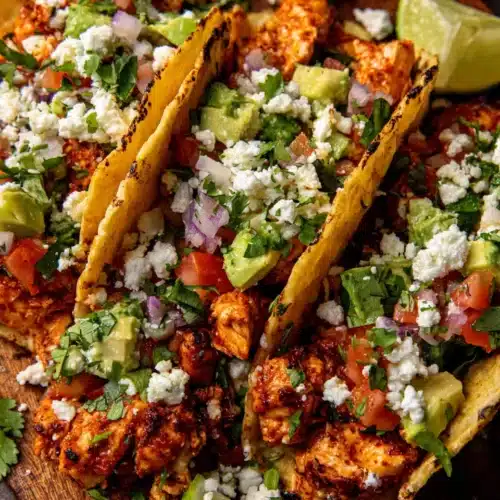 Flavorful chicken street tacos topped with cilantro and guacamole.