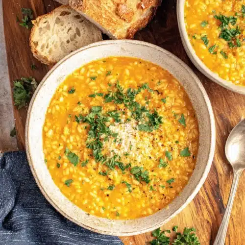 Delicious italian pastina soup garnished with parsley and cheese.