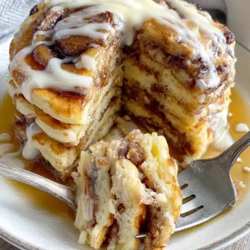 Delicious cinnamon roll pancakes drizzled with icing.