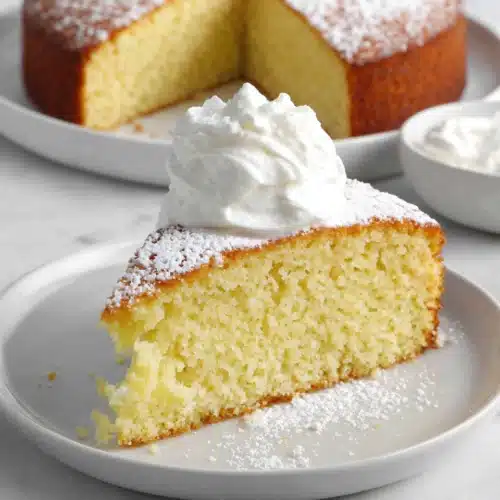 Delicious Irish Tea Cake slice topped with whipped cream.