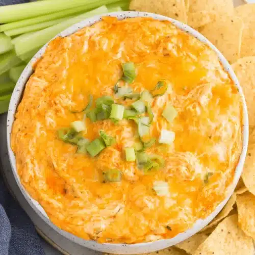 Delicious Slow Cooker Buffalo Chicken Dip served with chips and celery.