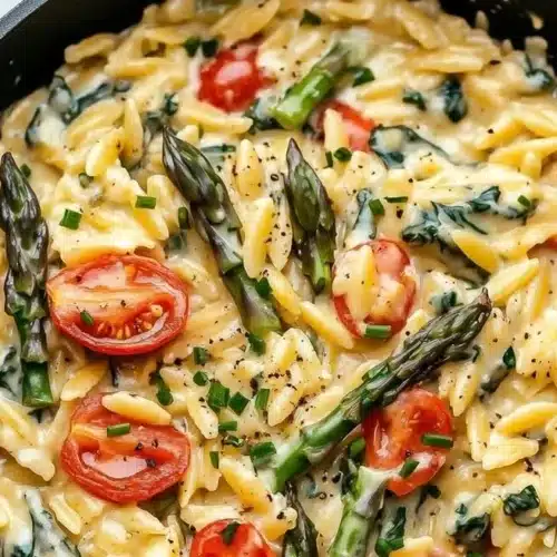 Delicious baked feta orzo dish topped with fresh herbs and cheese