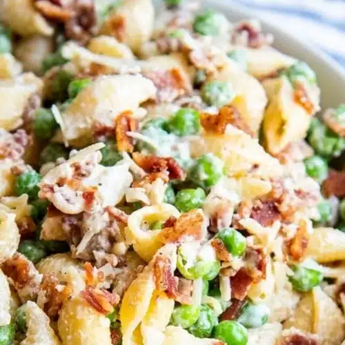 Creamy pasta salad with colorful vegetables and dressing in a bowl.