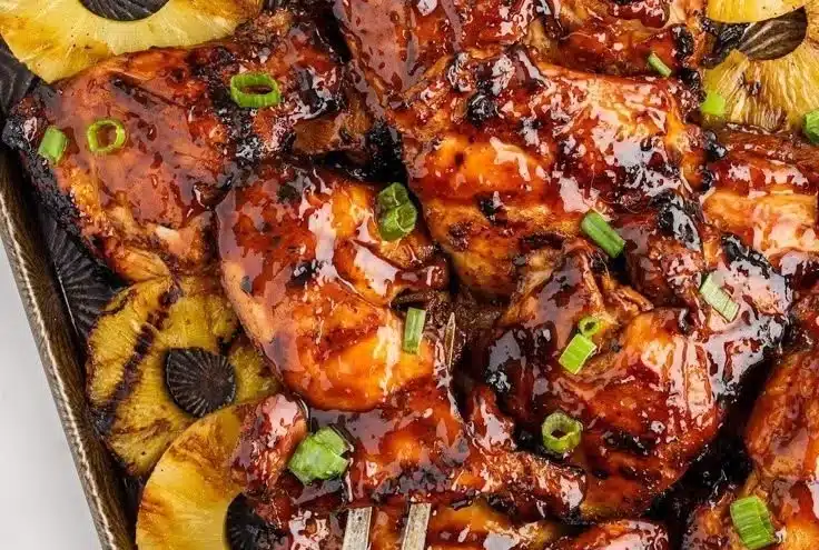 Delicious Huli Huli Chicken served with vibrant garnishes and dipping sauce