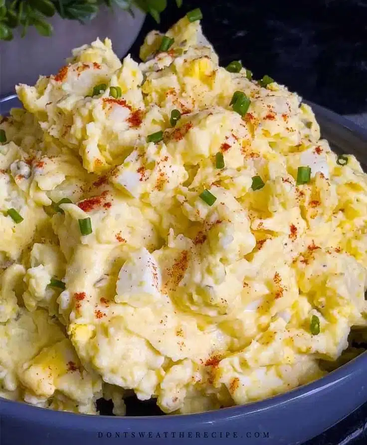 Delicious Southern potato salad garnished with chives and paprika