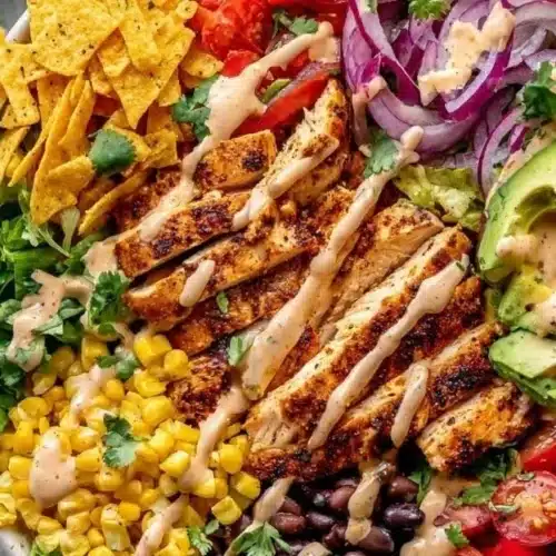 A colorful bowl of spicy avocado salad with fresh vegetables and herbs.