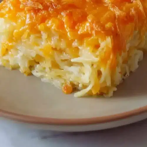 Creamy Cracker Barrel hashbrown casserole topped with cheese and crispy edges